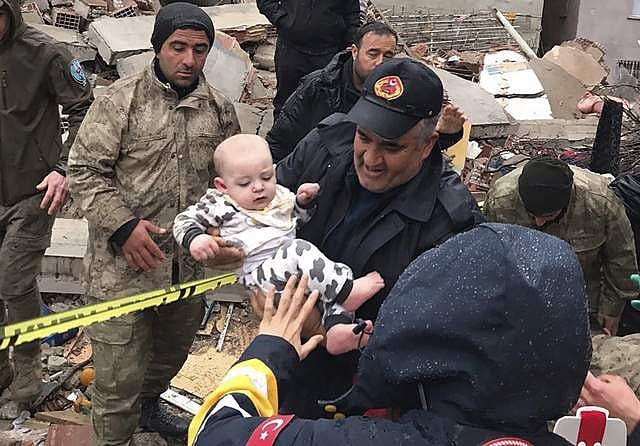 இடிபாடுகளிலிருந்து மீட்கப்படும் குழந்தை